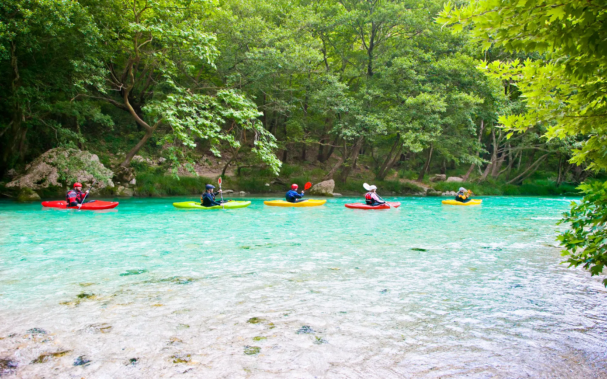a group of people in Acheron river kayaking