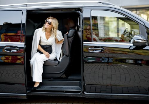 Elegant business lady in minivan taxi